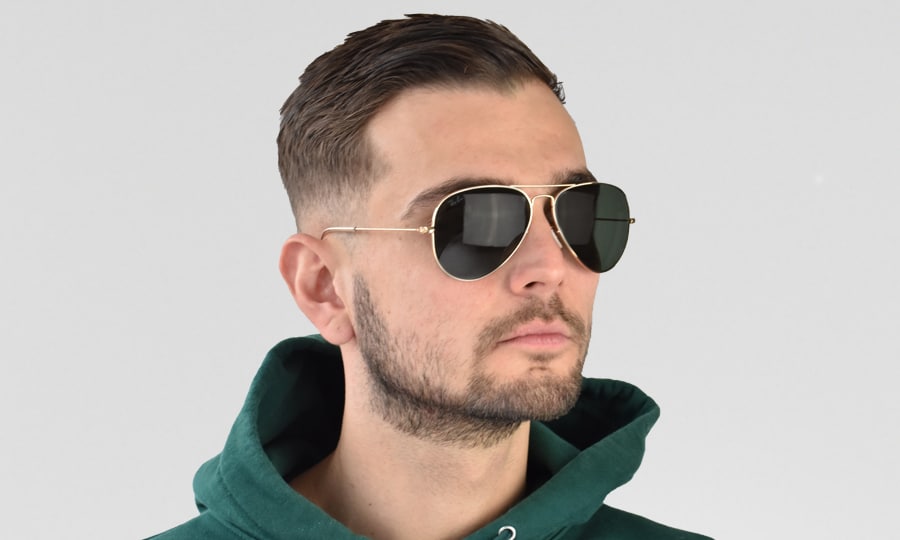 Ein Modellfoto eines Mannes, der die Ray-Ban Aviator RB3025-001 trägt
