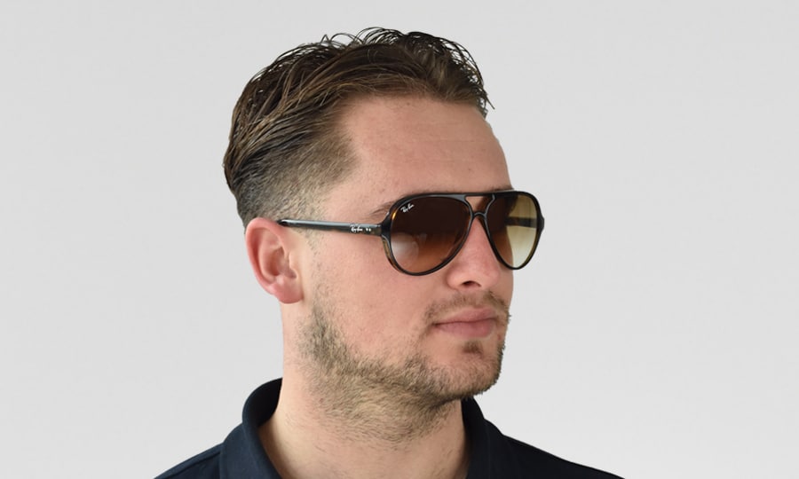 Ein Modellfoto eines Mannes, der die Ray-Ban Cats 5000 RB4125-710/51 trägt