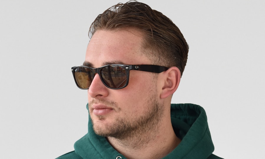 Ein Modellfoto eines Mannes, der die Ray-Ban New Wayfarer RB2132-710/51 trägt